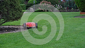 Robotic Lawn Mower on green grass background.Automatic robot lawnmower in modern garden.Green grass trimming with lawn