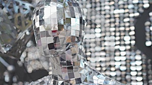 Robotic mannequin pasted over with square pieces of mirrors like disco ball