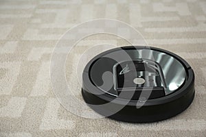 Robotic vacuum cleaner on carpet. Space for text