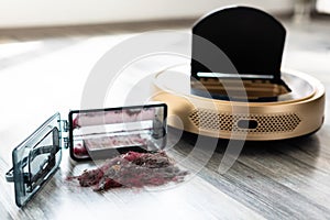 Robotic vacuum cleaner on wood floor with emptied dirt container