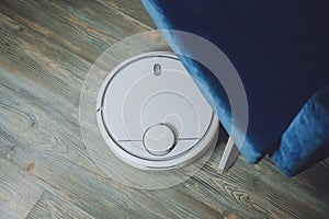 Robotic Vacuums, Robot Mops. Smart home. Automatic robotic vacuum cleaner on laminate wood floor, smart cleaning