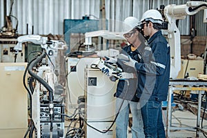 The robotic welding supervisor advice female worker to use a remote control panel