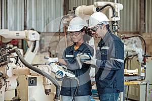 The robotic welding supervisor advice female worker to use a remote control panel
