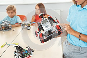 Robotics. Children having class sitting learning girl close-up with robot blurred background photo