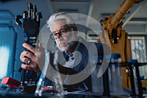 Robotics engineer adjusting, calibring robotic prosthetic hand. Concept of modern technology in medicine. Robotic