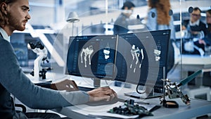 Robotics Engineer Working on Programming a Robot Dog on Desktop Computer. Young Team of