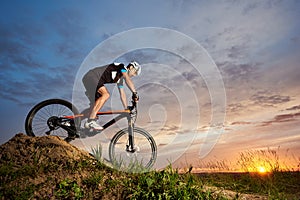 Robust cyclist riding bike and rolling down hill.