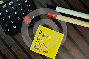 ROCE - Return On Capital Employed write on sticky notes isolated on Wooden Table