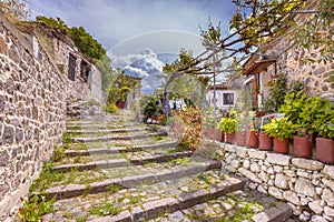 Rock alleyway staircase with gardens on Lesbos island Greece