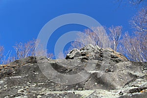 Rock, autumn trees and blue sky