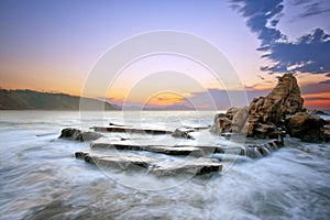 Rock in Azkorri beach at sunset