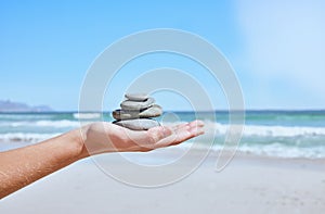 Rock balance, hand and beach for meditation, yoga or peace exercise in nature by water, Hands holding rocks for chakra