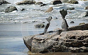 Rock balancing art on beach rocks in Laguna Beach, California.