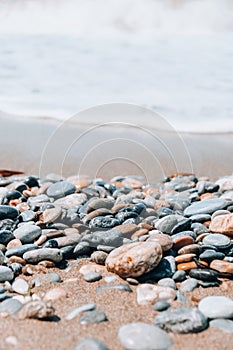 Rock balancing on ocean beach. Pyramid of pebbles on sandy shore. Stable pile or heap in soft focus with bokeh, close up