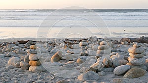 Rock balancing on pebble beach. Pyramid stacks of stones, ocean coast, sea water