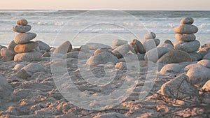 Rock balancing on pebble beach. Pyramid stacks of stones, ocean coast, sea water