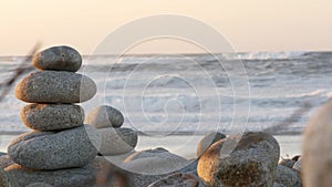 Rock balancing on pebble beach. Pyramid stacks of stones, ocean coast, sea water