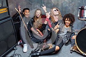 Rock band sitting on floor while resting after rehearse in studio photo