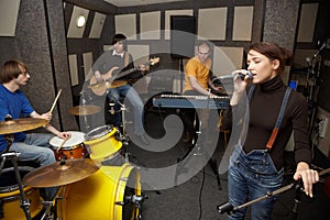 Rock band in studio. vocalist girl is singing
