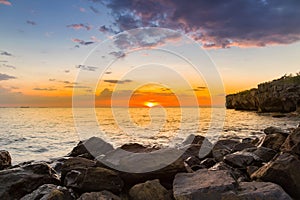 Rock beach over sunset skyline