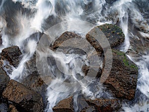 Rock-bound coast with silky water waving back to the sea