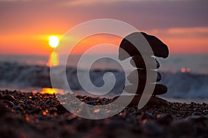 A rock cairn on the beach of Lake Superior at sunset.