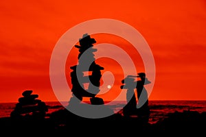 Rock cairns silhouetted by red orange background