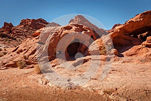 Rock cave and other formations near Elephant Rock during sunny day with blue sky, Valley of Fire State Park, Nevada