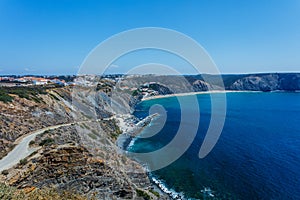 Rock cliff arches on beach and turquoise sea water on coast of Portugal.