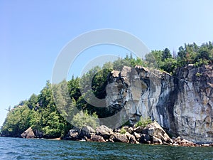 Rock Cliff Face Forested Hill on a Lake photo