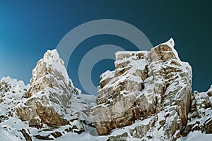 Rock cliff in frost after blizzard. Snow on mountain block. Ice makes it difficult to climb to top