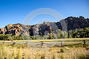 Rock cliffs and a pature with horses on it in Wyoming photo