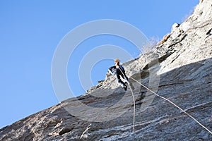 Rock climber abseiling off a climb