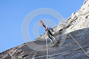 A rock climber abseiling off a climb