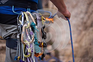 A rock climber belays his partner while he climbs up a rock wall