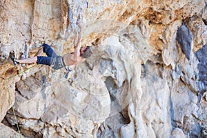 Rock climber on challenging route on cliff