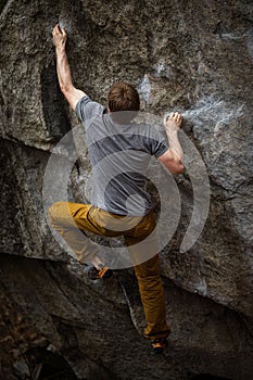 A rock climber climbing on a boulder rock outdoors