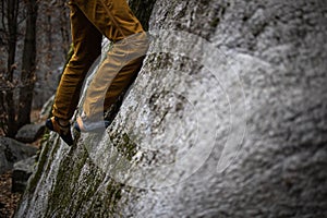 A rock climber climbing on a boulder rock outdoors