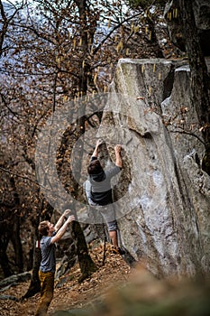 A rock climber climbing on a boulder rock outdoors