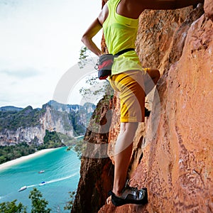 Rock climber climbing on seaside cliff