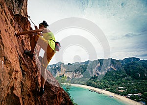 rock climber climbing on seaside cliff