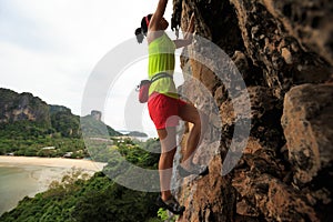 rock climber climbing at seaside cliff