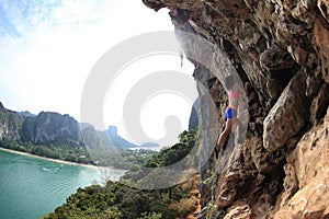 Rock climber climbing at seaside mountain rock