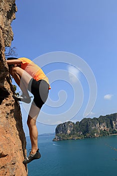Rock climber climbing at seaside mountain rock