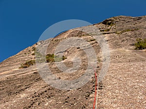 Rock climber climbing a sloping rock wall