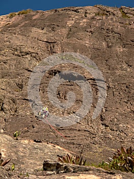 Rock climber climbing a sloping rock wall