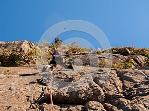 Rock climber climbing a sloping rock wall