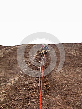 Rock climber climbing a sloping rock wall