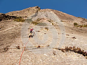 Rock climber climbing a sloping rock wall