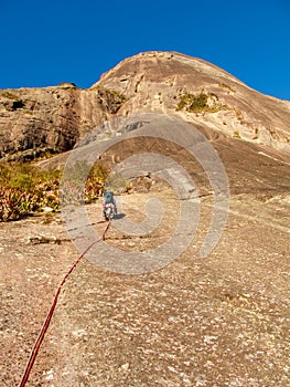 Rock climber climbing a sloping rock wall